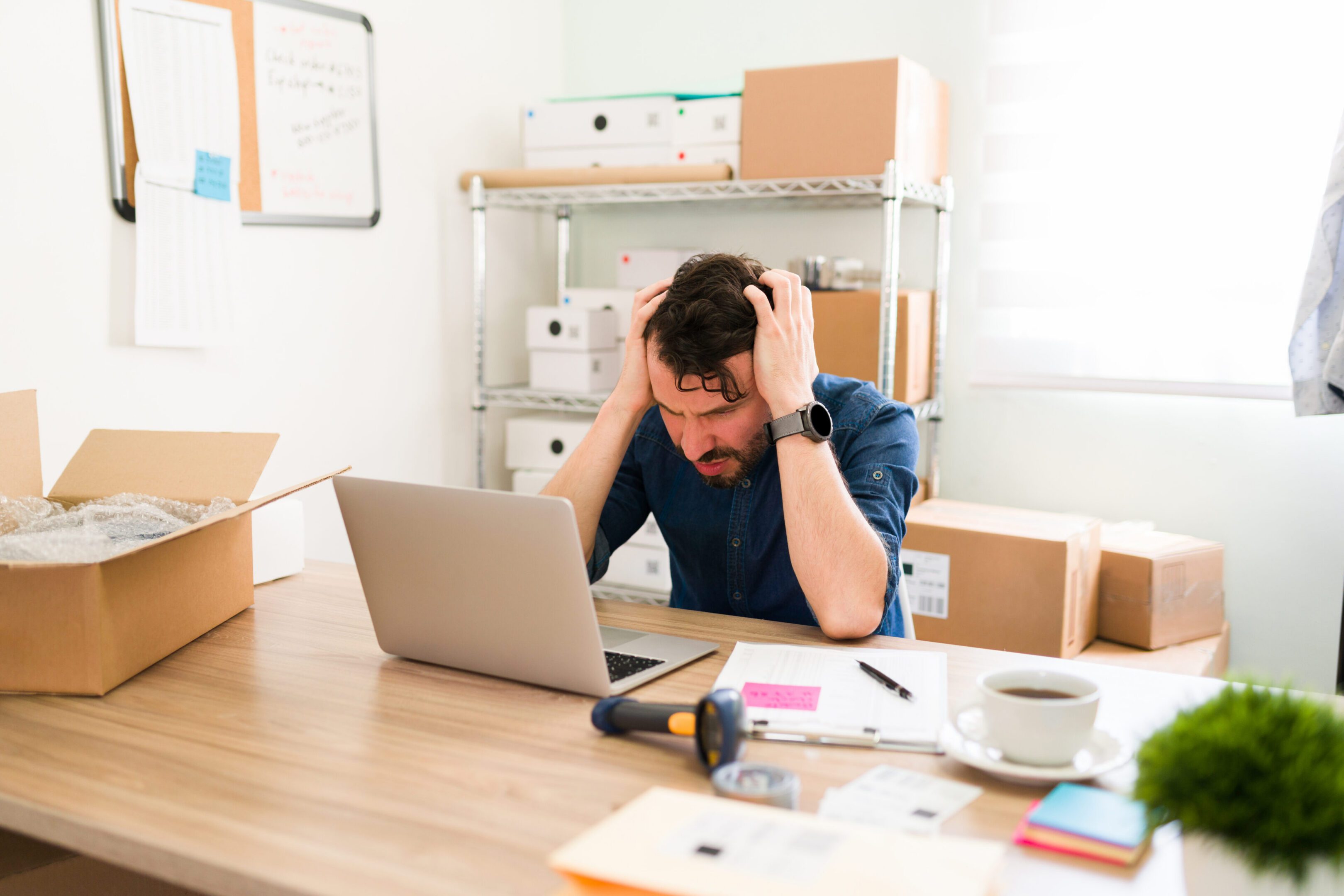 Hispanic business owner having problems with his startup company. Upset  entrepreneur feeling stressed and worried while looking at the laptop screen